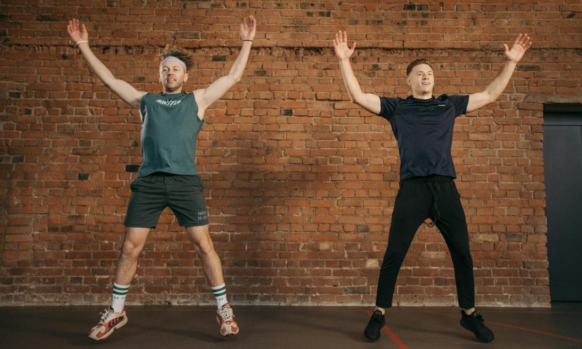 two men doing jumping jacks jumping working out