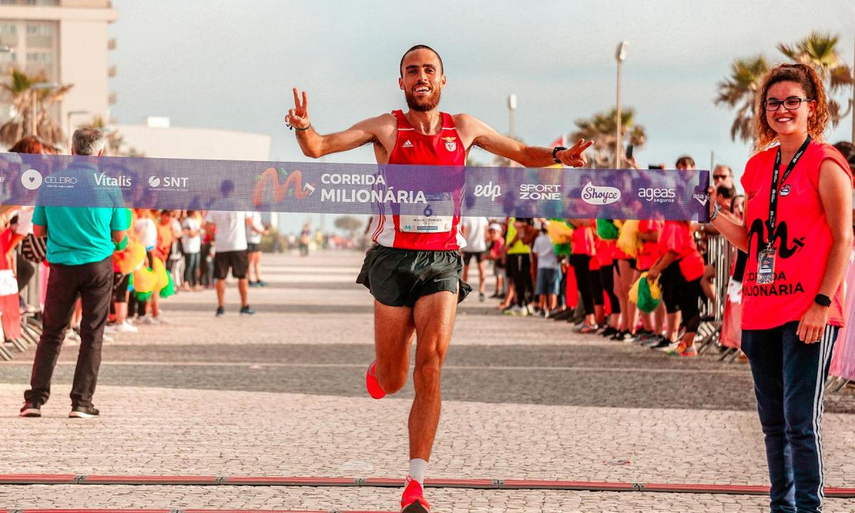 Happy man smiling crossing marathon finish line