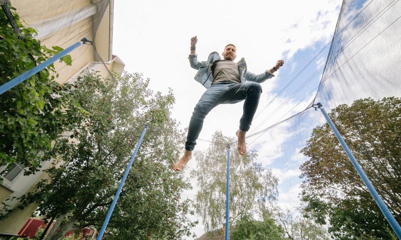 man jumping on trampoline rebounder