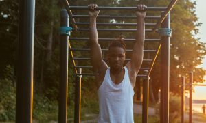 man pullup dead hang outdoor workout sunset