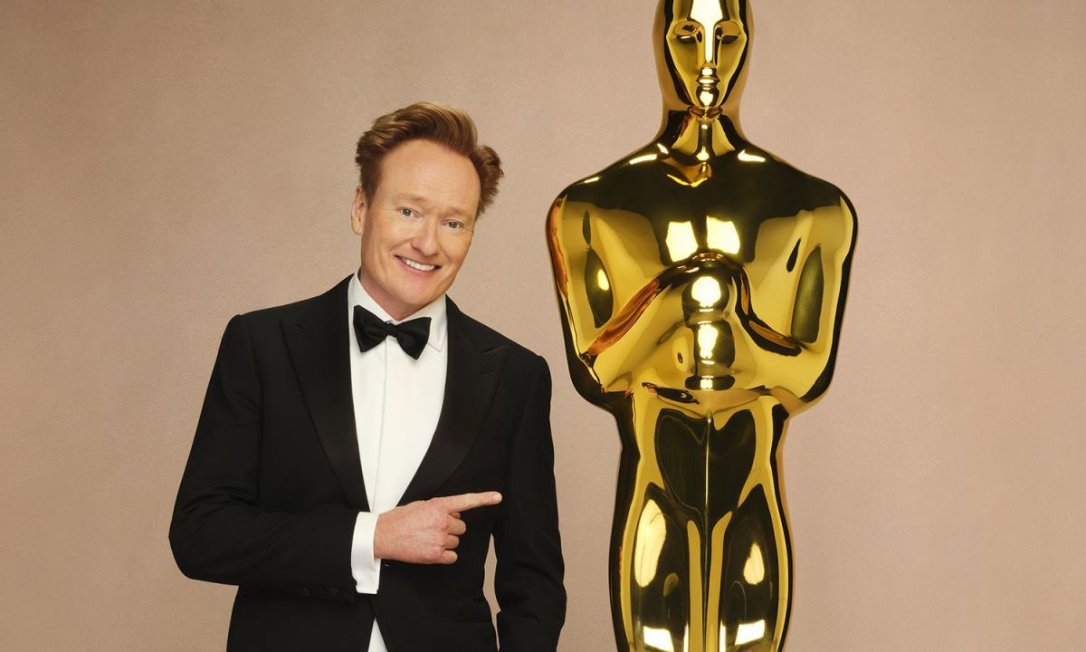 Conan OBrien next to an Oscars statue