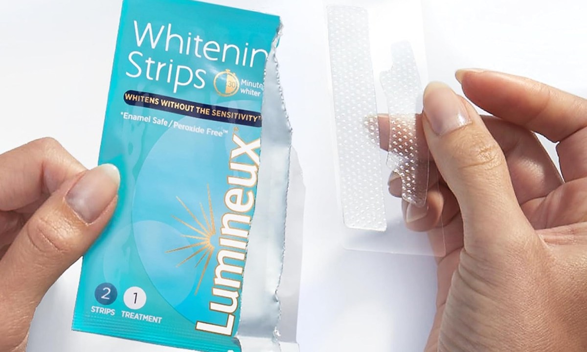 A person holding the Lumineux Teeth Whitening Strips.
