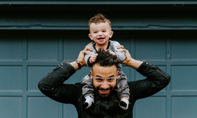 Happy dad with child on shoulders