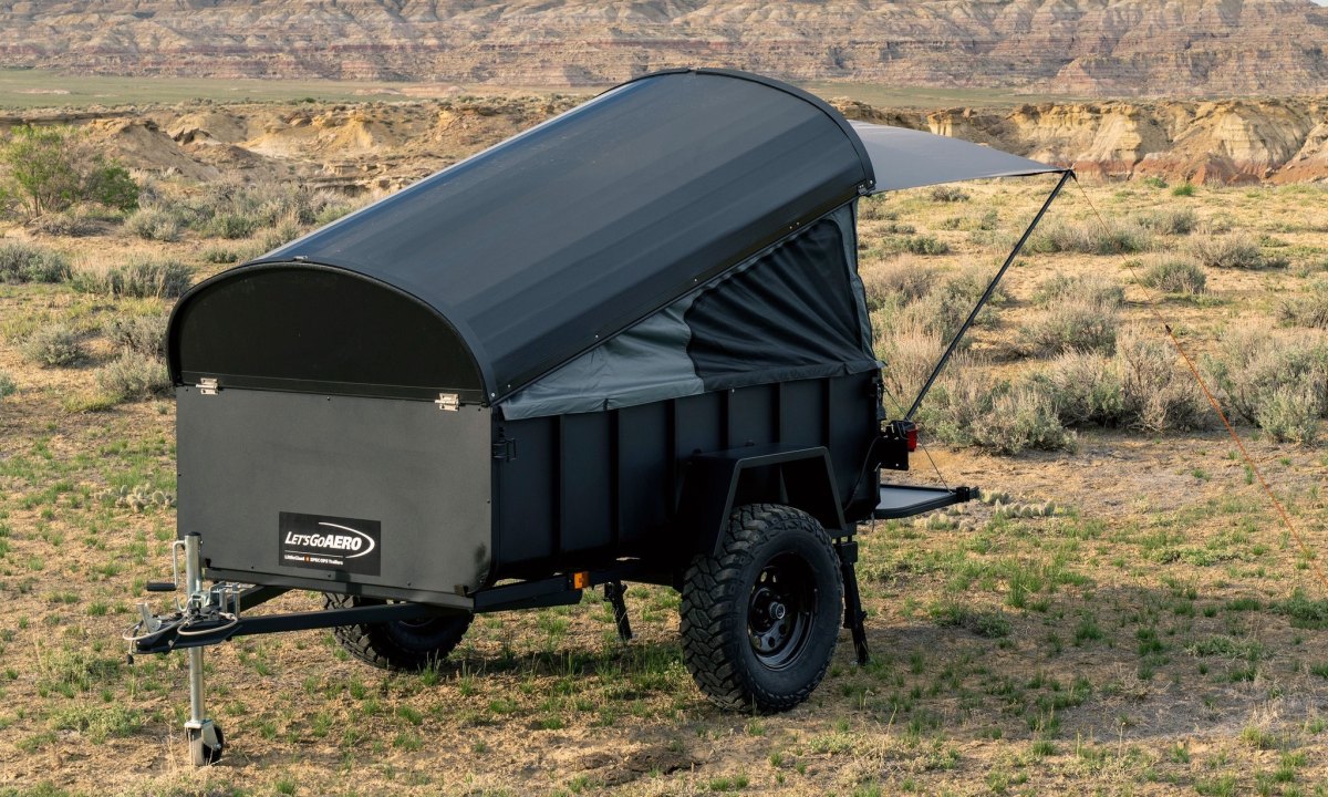 A Let's Go Aero LittleGiant CrashPad camper trailer setup up to camp in a backcountry field.