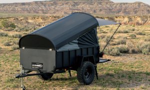 Let's Go Aero LittleGiant CrashPad camper trailer parked in a field.
