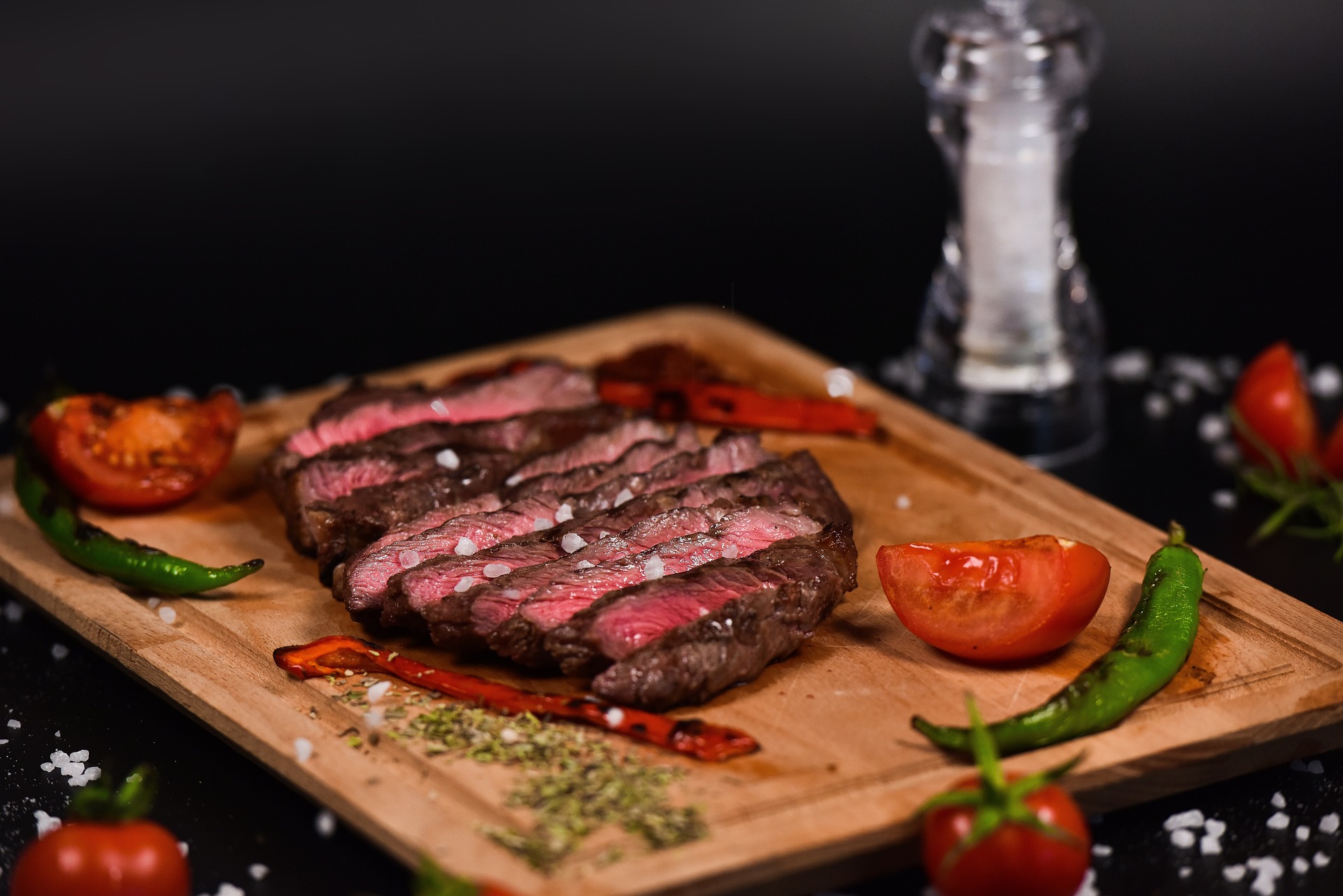 sliced steak and peppers on a cutting board
