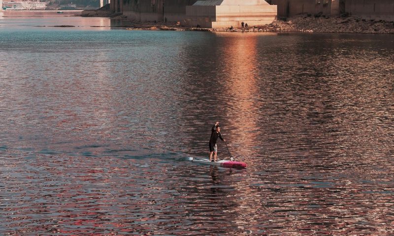 Man paddleboarding on water