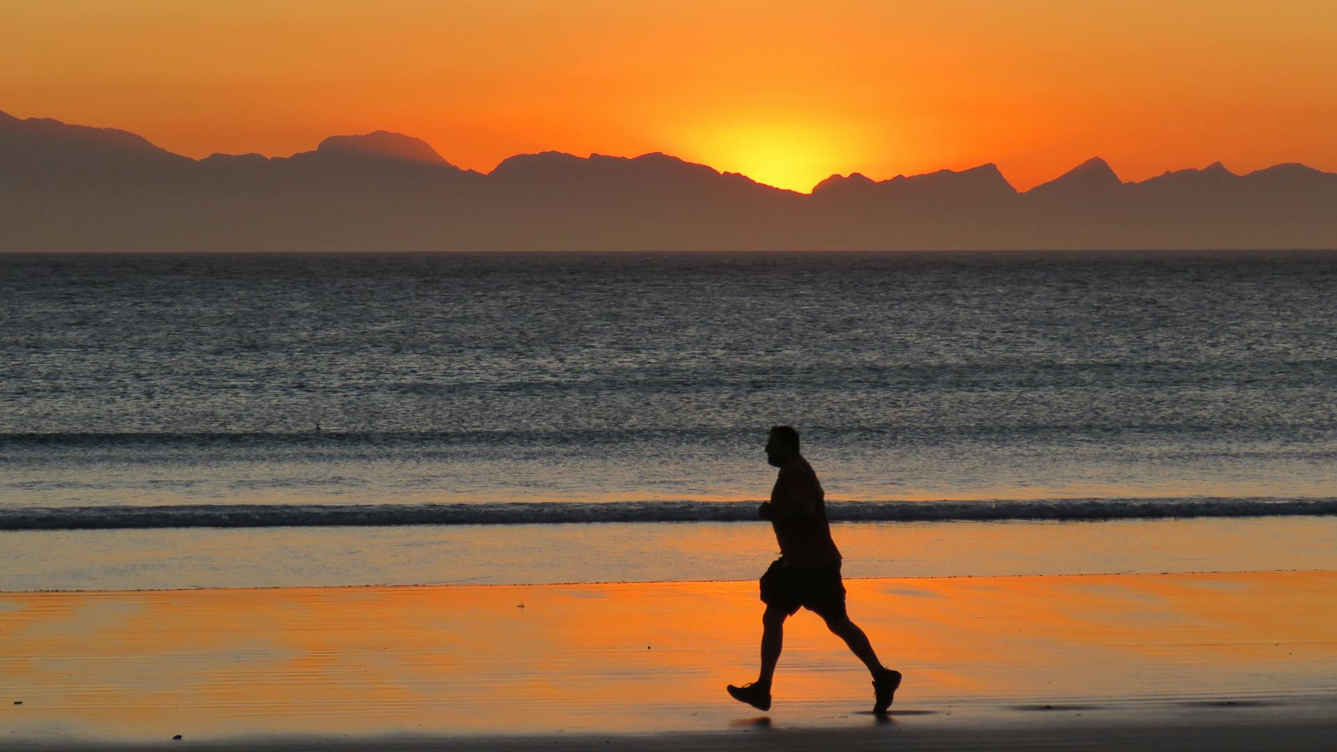 man running at sunset on beach