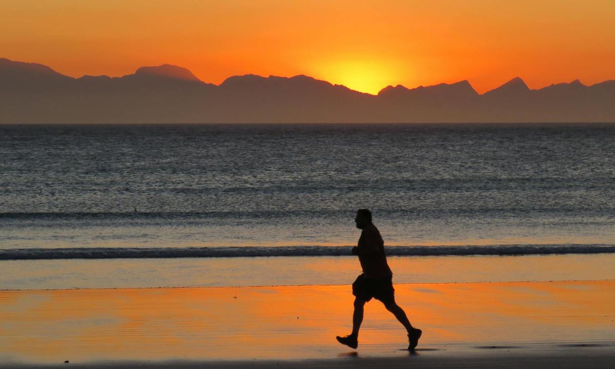 man running at sunset on beach