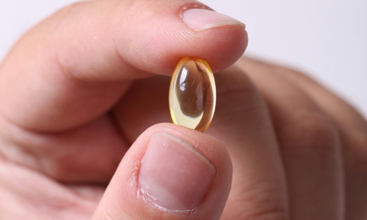 Close-up of hand holding soft gel vitamin