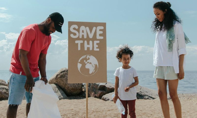 family cleaning up trash on beach cleanup