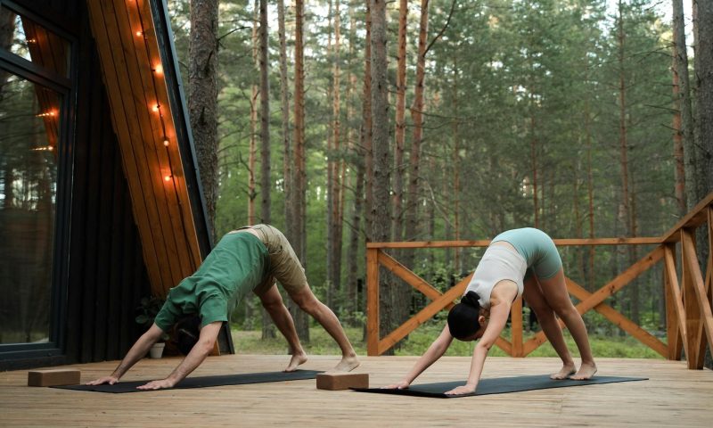 man and woman doing downward dog yoga pose