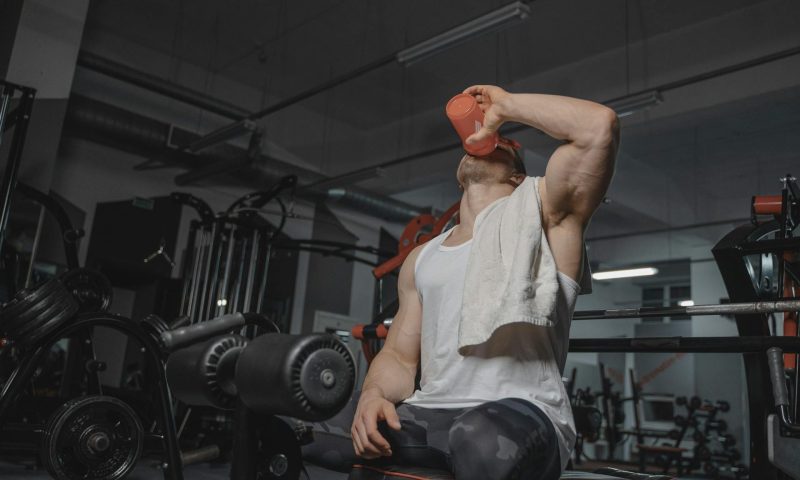man drinking protein shake in gym