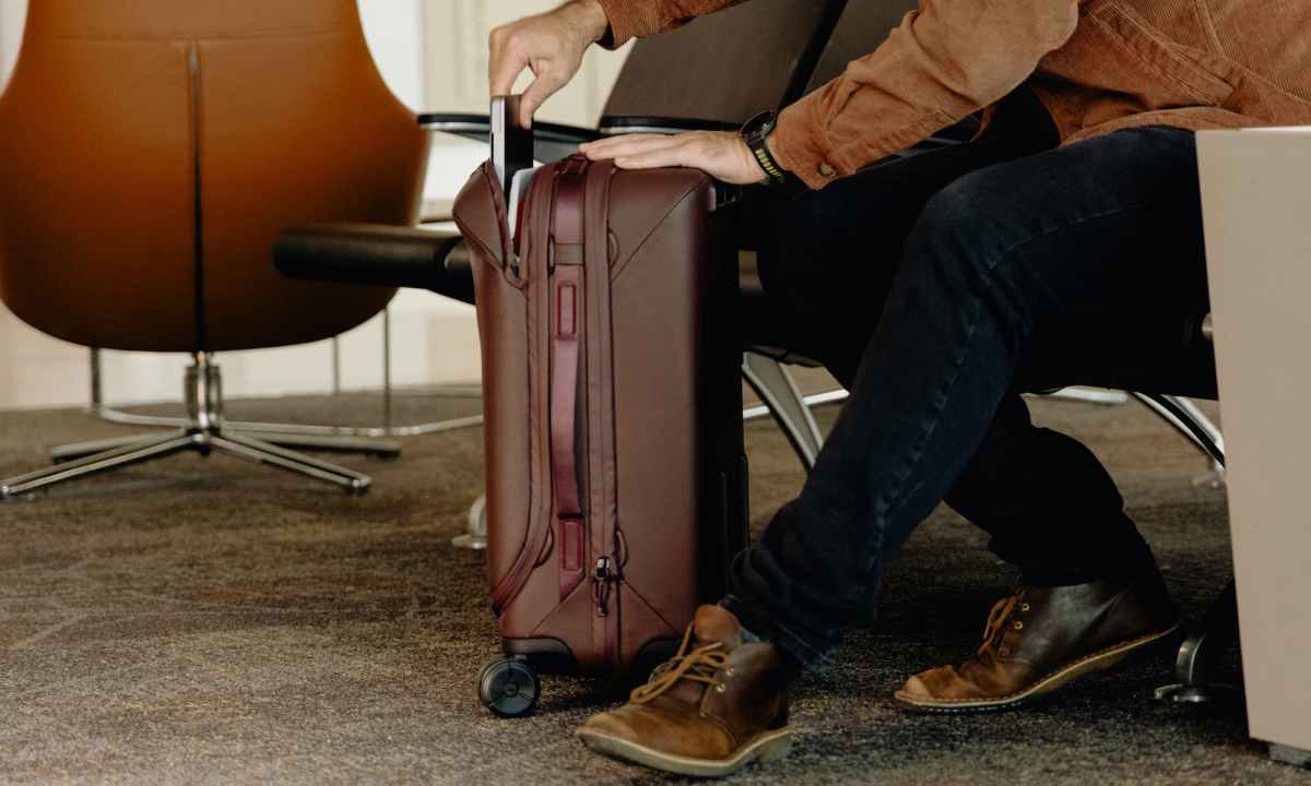 man putting a laptop in Peak Design Roller Pro carry-on