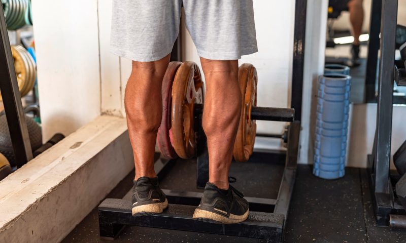 man doing standing calf raise in gym