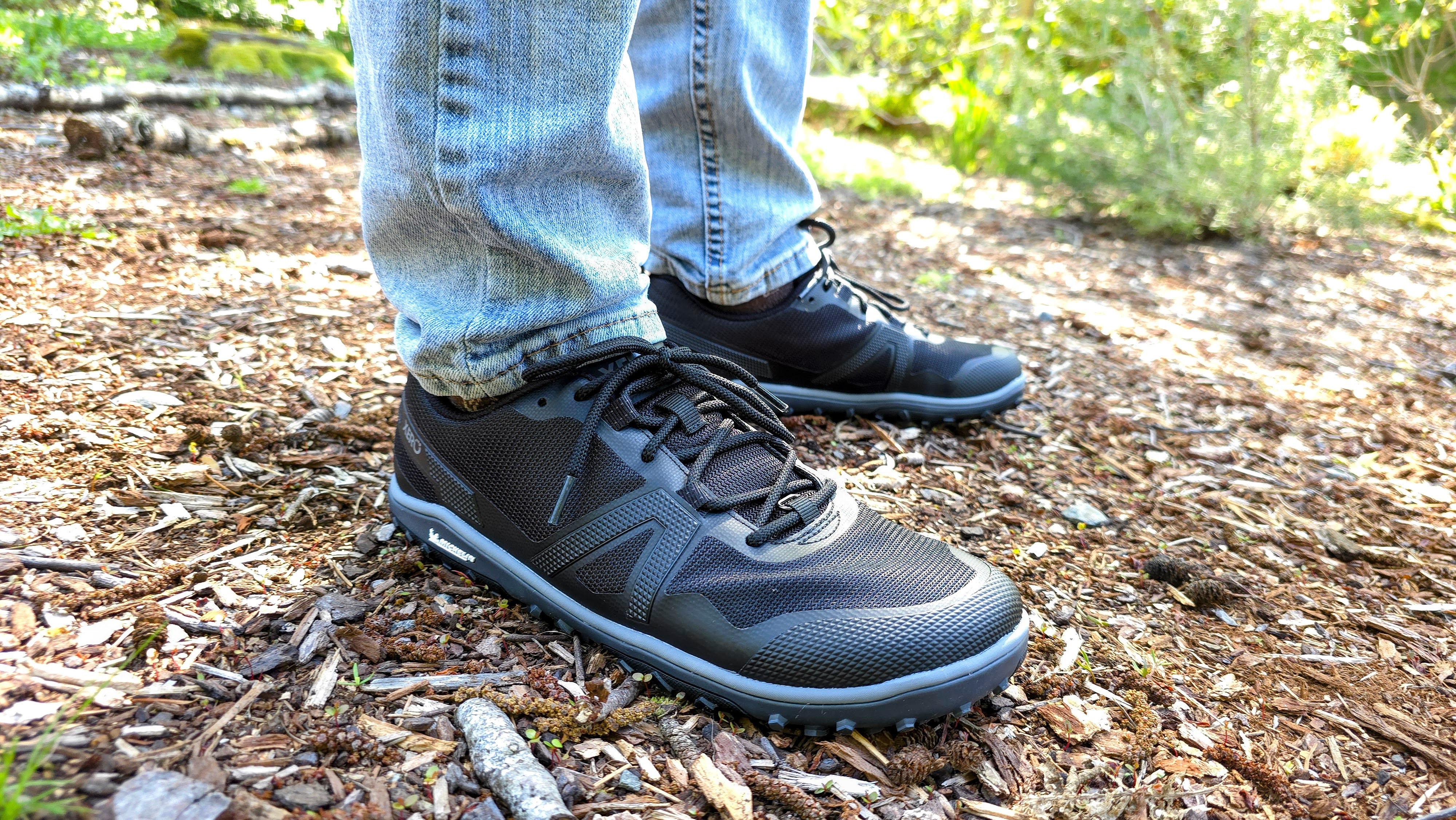 A man wearing Xero shoes while standing still