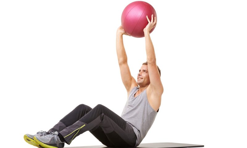 man doing zombie sit up with workout ball