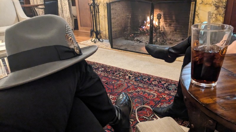 Hat on a knee with fireplace in the background