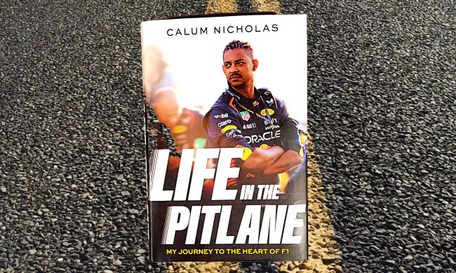Life in the Pitlane by Calum Nicholas bookcover shot against road with yellow centerlines.