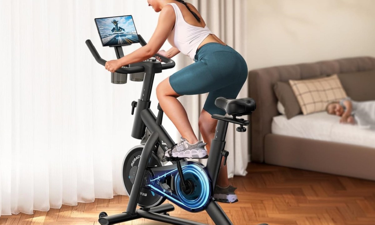 A woman using the Merach S26 Exercise Bike.