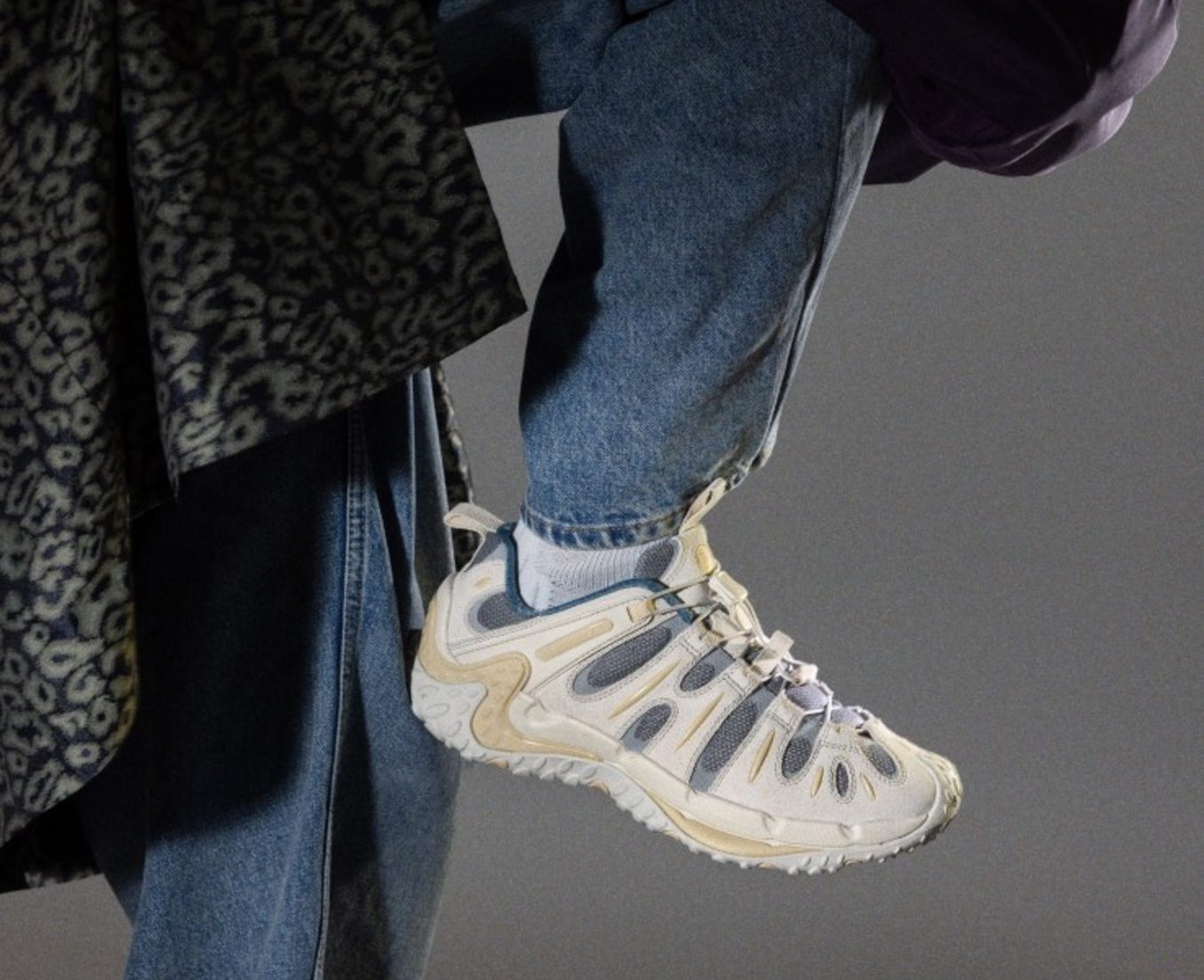 model holding up white sneaker