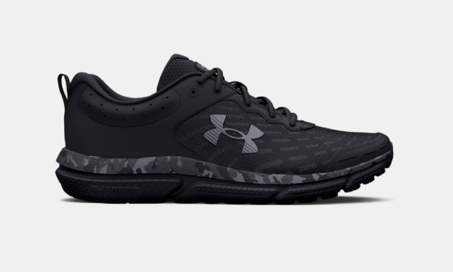 The Under Armour Charged Assert 10 Camo Running Shoes on a gray background.