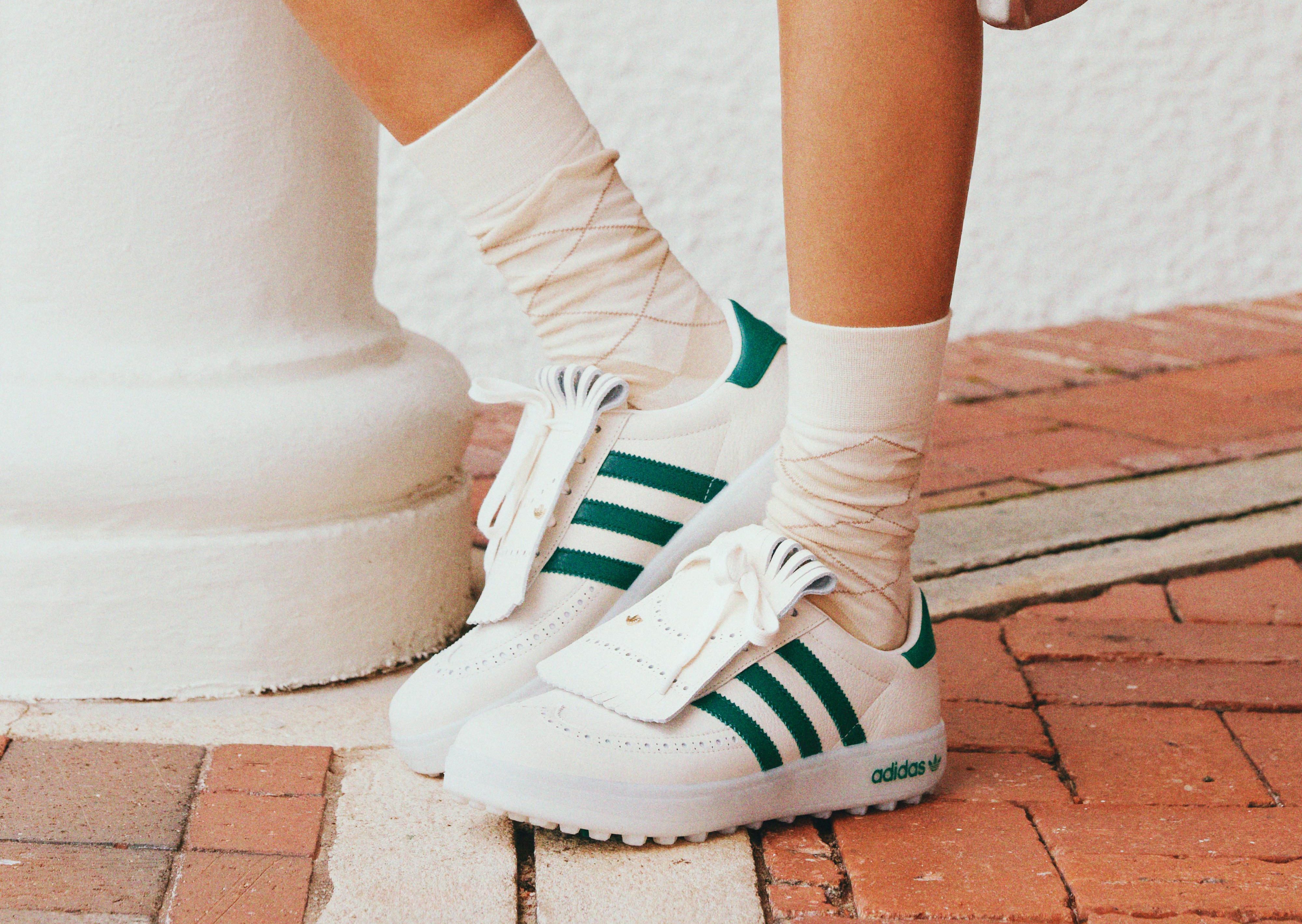 person wearing adidas golf shoes