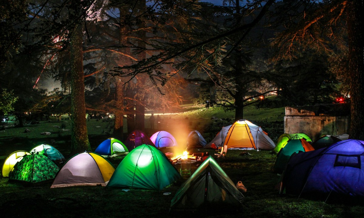 Festival camping tents glowing from flashlights at night