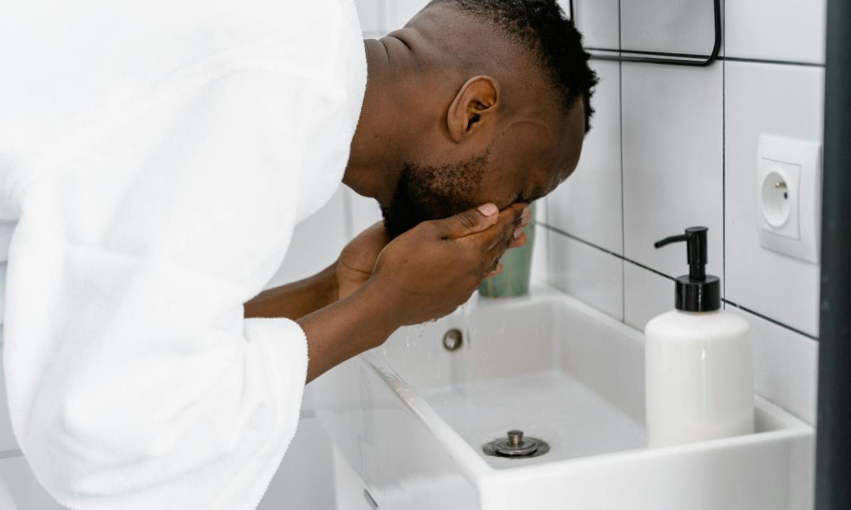 man washing face in bathroom