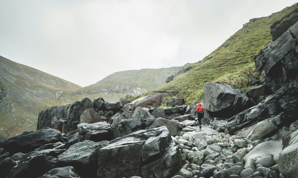 Man in a red coat hiking in the rain