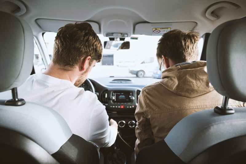 two men sitting inside car