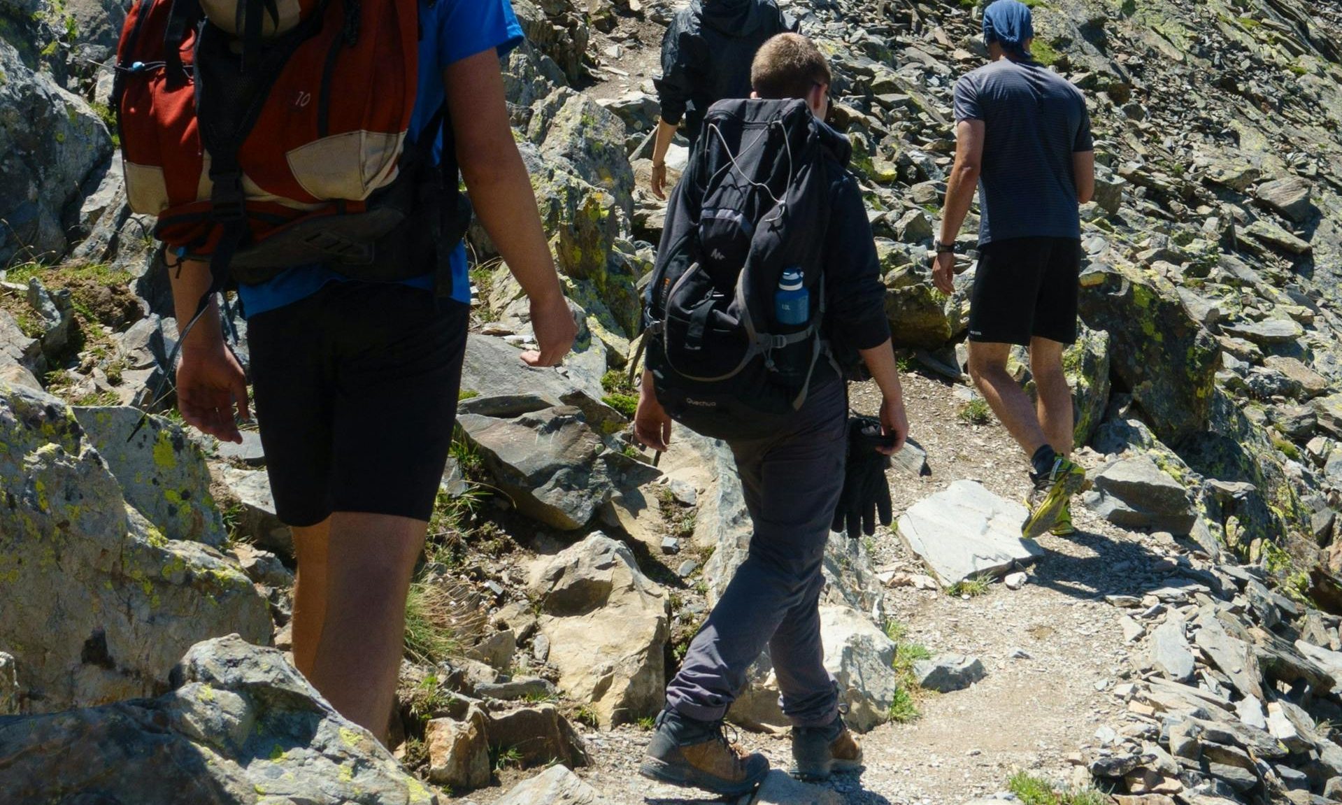 -men walking hiking on rocky hill