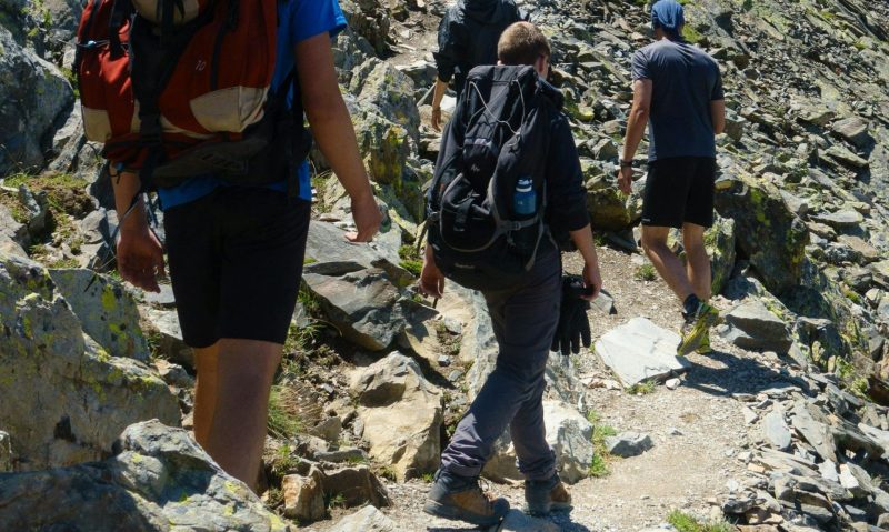 -men walking hiking on rocky hill