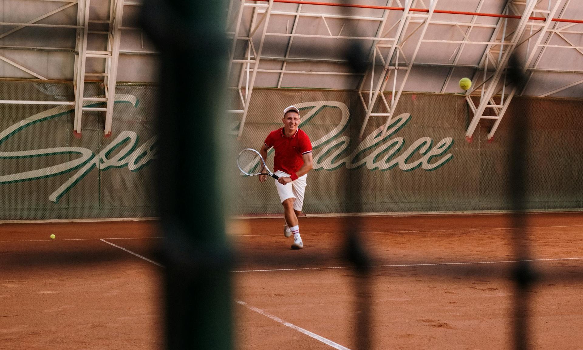 man playing tennis running