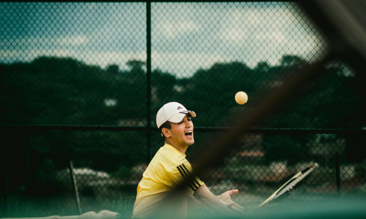 Man swinging tennis racket playing tennis happy