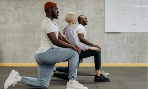 Men and a woman doing lunges bodyweight training