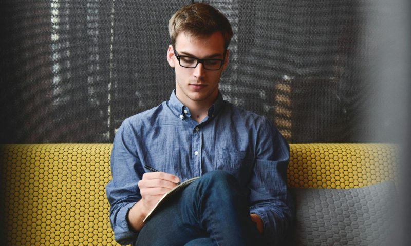 Man writing in journal or book