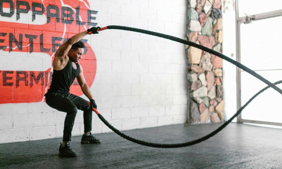 man doing HIIT ropes gym