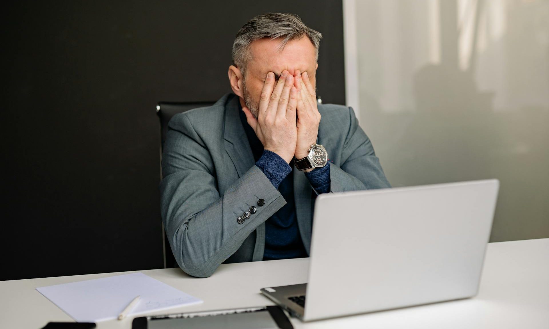 Man head in hands tired stressed laptop