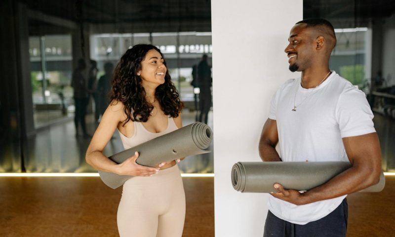 Man and woman holding yoga mats