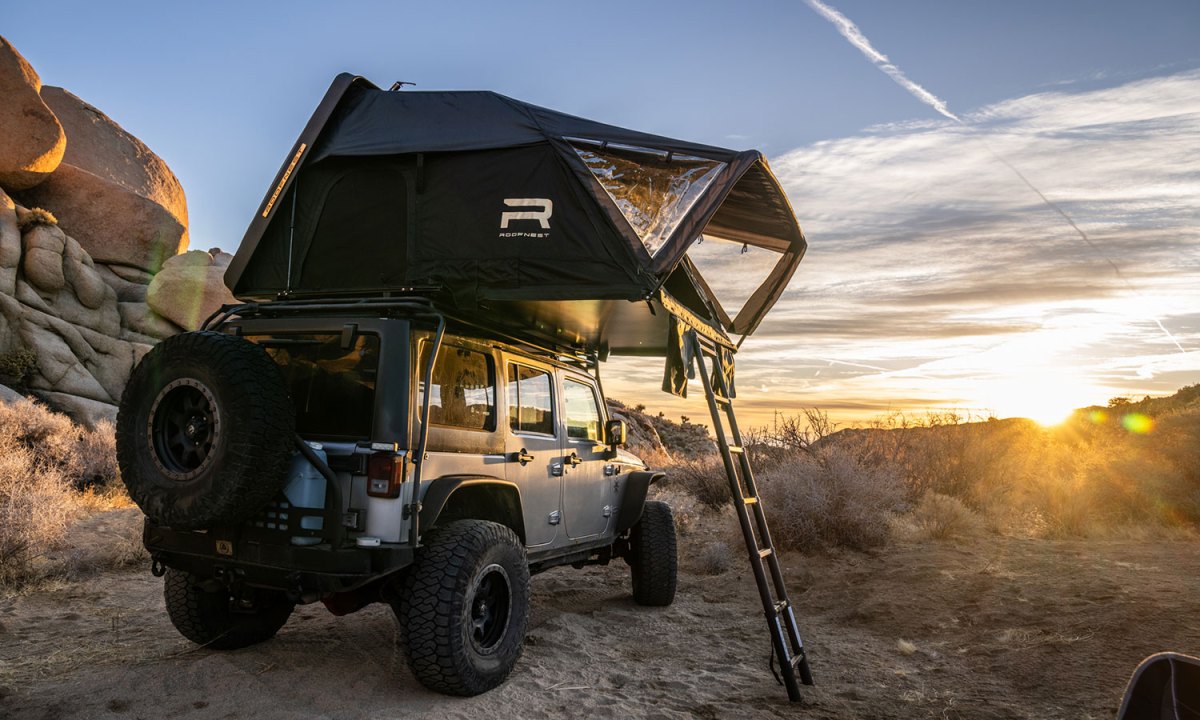 Roofnest Condor 2XXL Air rooftop tent mounted on a Jeep Wrangler parked in the desert.