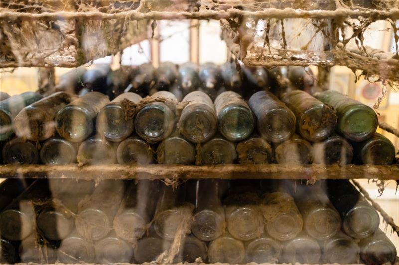 A rack of cobwebby old bottles of madeira wine.