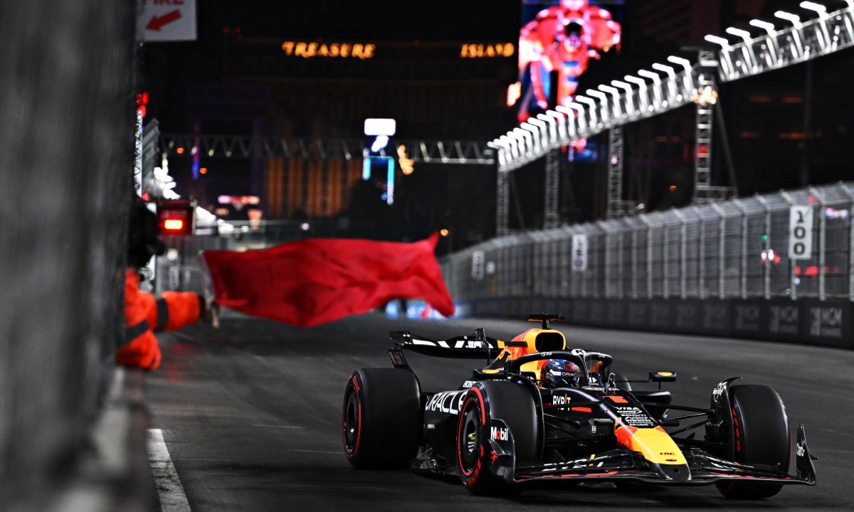 A track marshall waving a red flag at Las Vegas Grand Prix.