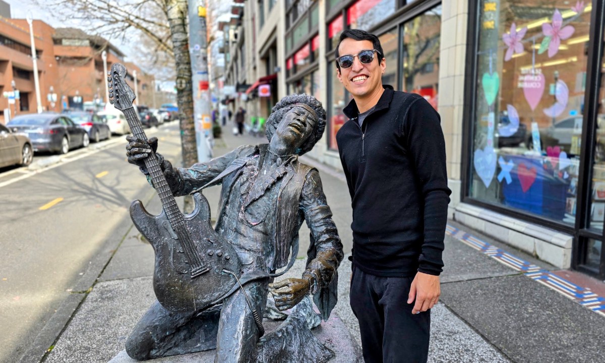 Raul Mercado standing next to Jimi Hendrix Sculpture in Seattle