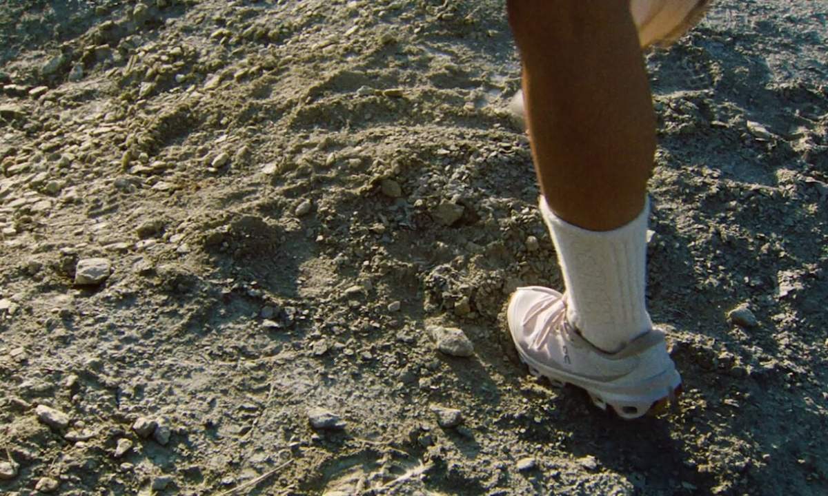 man wearing loewe x on sneaker in dirt