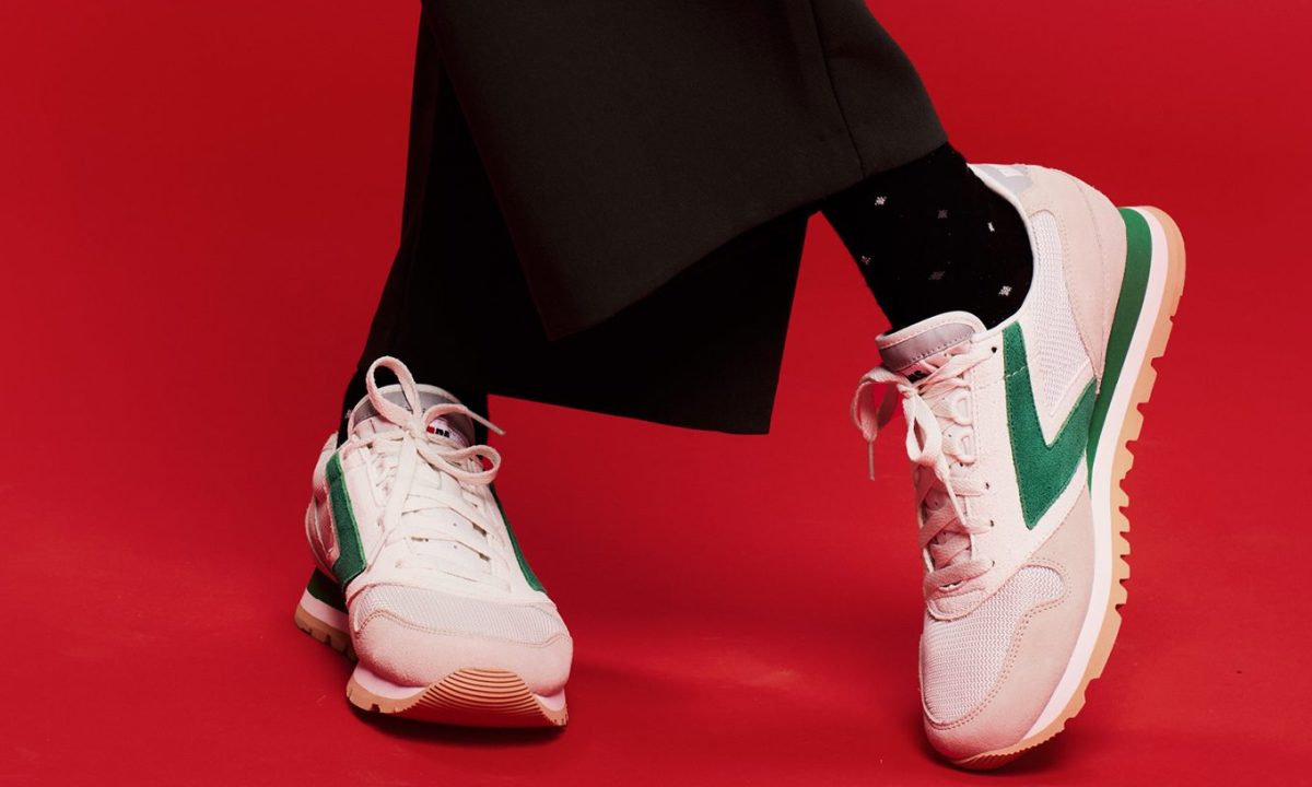man wearing white and green brooks running shoe