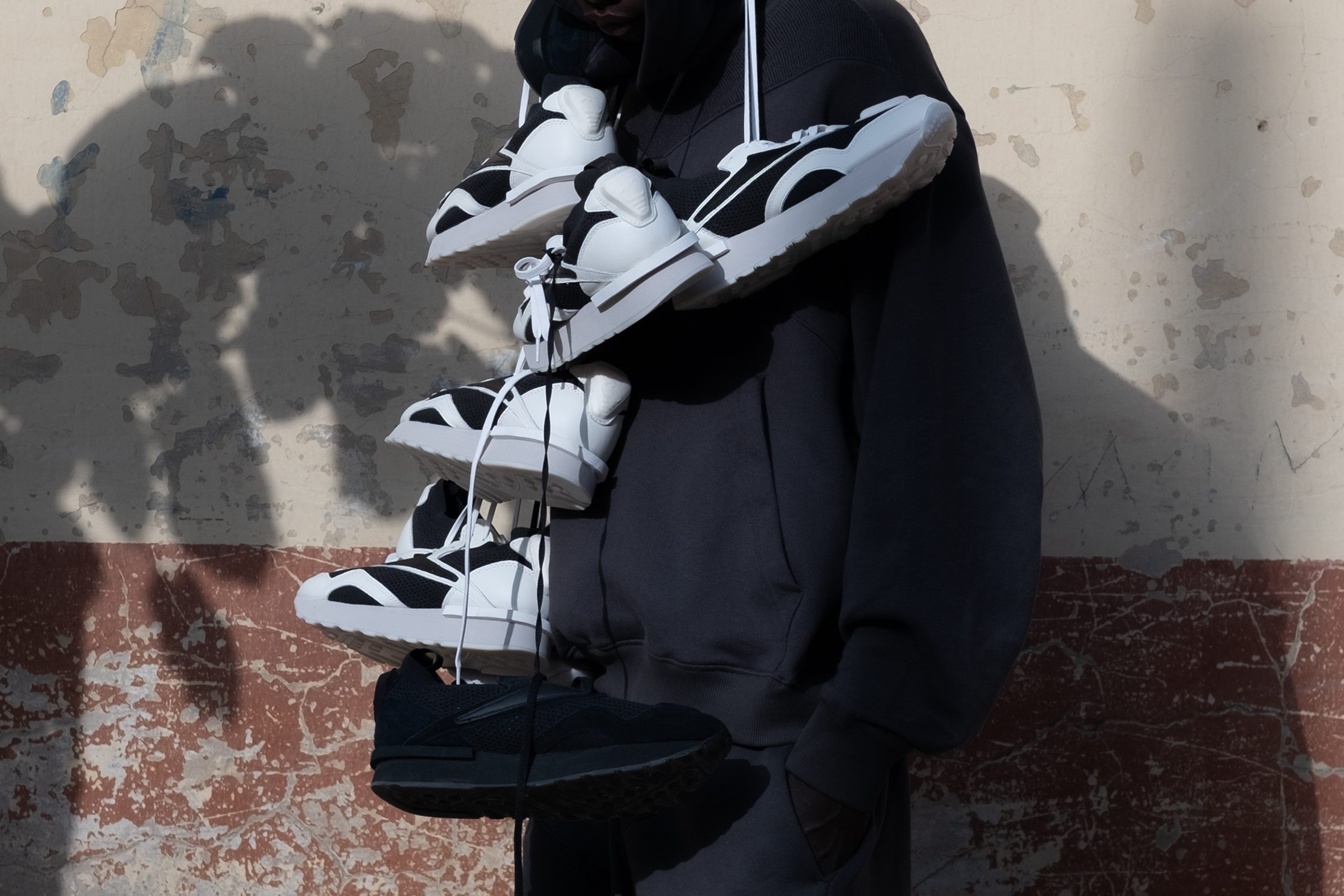 man wearing reebok sneakers around his neck