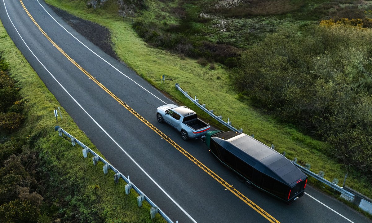 Lightship's all-electric AE-1 Cosmos Edition travel trailer being towed by a Rivian pickup truck.