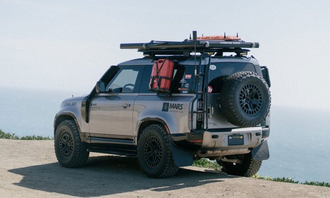 Mars' Aeroblade rooftop tent mounted atop a 2-door SUV parked near the ocean.