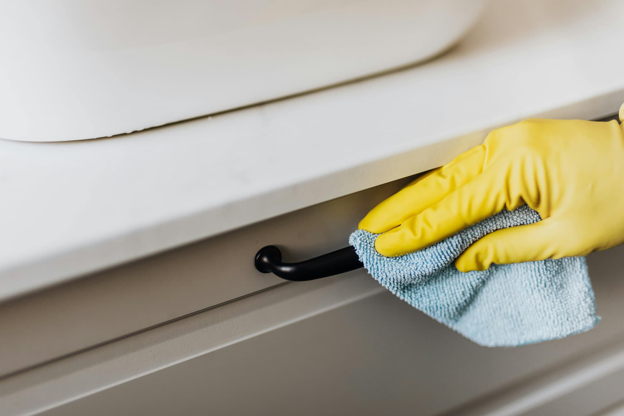 person cleaning counter with a rag